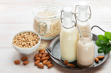 Obraz na płótnie Canvas Alternative types of vegan milks in glass bottles