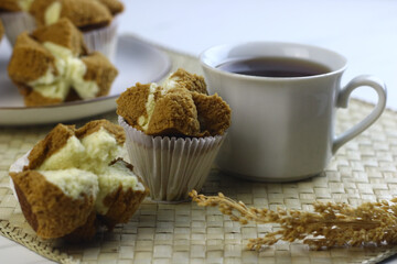 Bolu Kukus Cokelat or Flower bloom steam cake, Indonesian traditional cake, with chocolate flavour. White bright background. Morning tea concept.