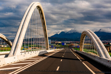 Highway as it passes over a bridge on the A44 in Granada, on a cloudy day and with the Huetor Santillan mountains in the background.