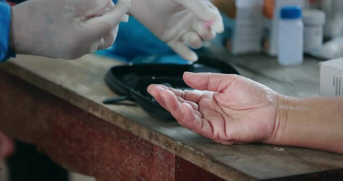 Doctor making blood sugar test and checking blood sugar level.