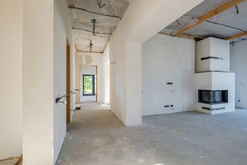 Fototapeta na wymiar Empty unfurnished corridor room with minimal preparatory repairs. interior with white walls and drywall