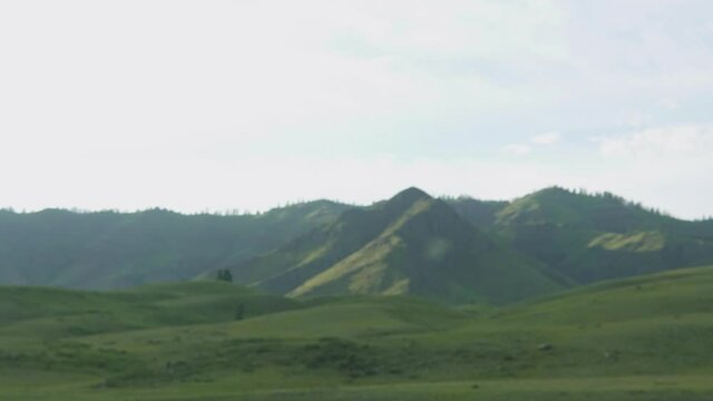 Evening over grassy hills and the setting of the summer sun. The twilight deepened. Cloud-drift. Timelapse
