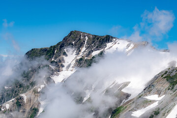 Fototapeta na wymiar 雪と雲を纏う山