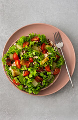Light summer fresh salad with tomatoes and lettuce, chicken breast and pineapple with balsamic sauce, top view