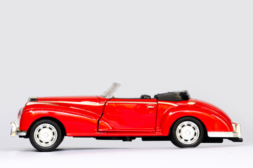 Beside view of roster red car. Classic model made by steel material. On isolated white background.