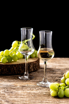Italian golden grappa drink on wooden background