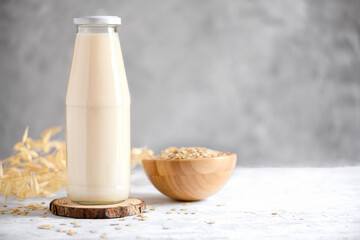 Vegan non dairy alternative milk. Oat milk on grey stone table