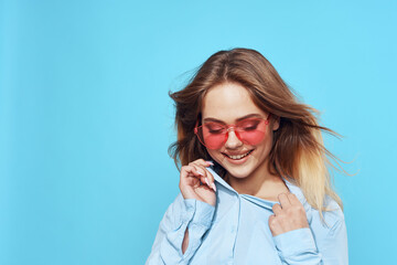 womens blue shirt pink glasses posing fashion blue background