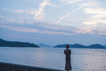 Fototapeta na wymiar 夕暮れの海にいる女性