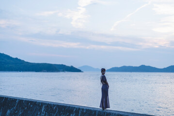 Fototapeta na wymiar 夕暮れの海にいる女性