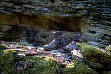 Old run-down boots with moss over the wall