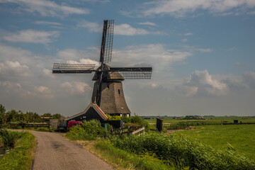 Fototapeta premium Schoorl, the Netherlands. July 2021. Dutch landscape with windmill and thatched roof.