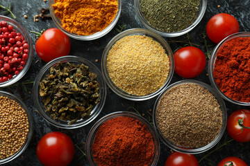 Aromatic spices in bowls on black smokey background