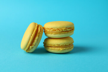 Concept of tasty dessert with macaroons on blue background