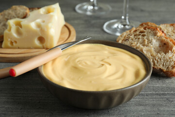 Concept of delicious food with fondue on gray textured table