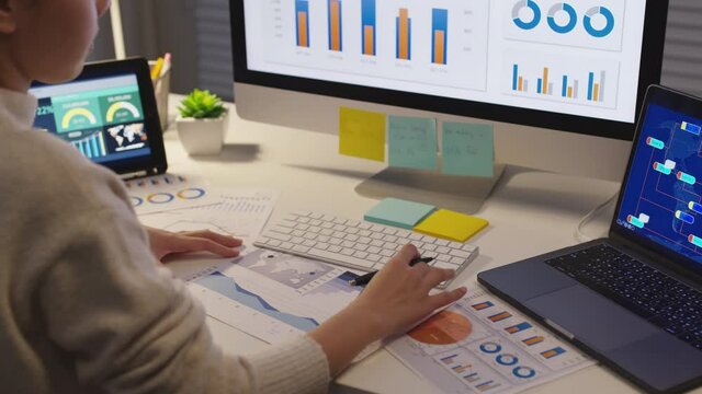 Asia people busy remote work at desk home office late night in digital self reskill upskill for job career plan in MBA learn online class study. Stock big data graph chart SEO sale report on screen.