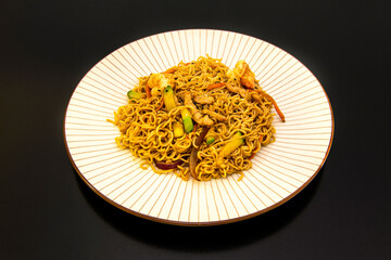 Chinese curly rice noodles with sautéed vegetables and pork and prawns with yakisoba sauce on white plate and brown stripes