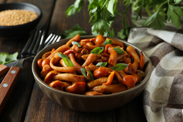 Concept of tasty food with marinated mushrooms on wooden table