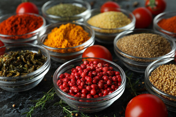 Aromatic spices in bowls on black smokey background