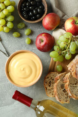 Concept of delicious food with fondue on gray textured table