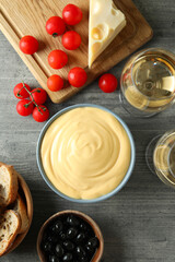 Concept of delicious food with fondue on gray textured table