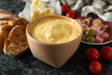 Concept of delicious food with fondue on black smokey table