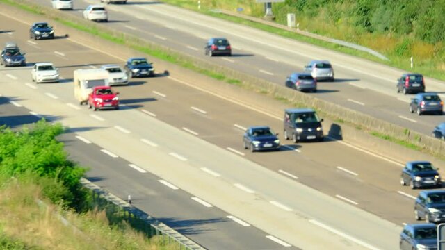 blurred traffic of cars that travel fast on A5 expressway in Germany, daytime traffic in suburbs of Frankfurt am Main, trucking concept, pendlers returning from work, top view