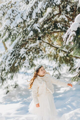 Fototapeta na wymiar Portrait of a girl walking in the winter outdoors. Playing with snow. children outdoor