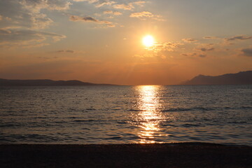 Sunset on the beach by the sea on a summer evening, Makarska, Croatia
