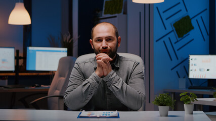 Fototapeta premium Pov of exhausted businessman discussing with remotely colleague working at financial digital project deadline during videocall conference meeting. Tired entrepreneur working in startup company office