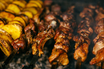 potatoes and shish kebab are fried on the grill