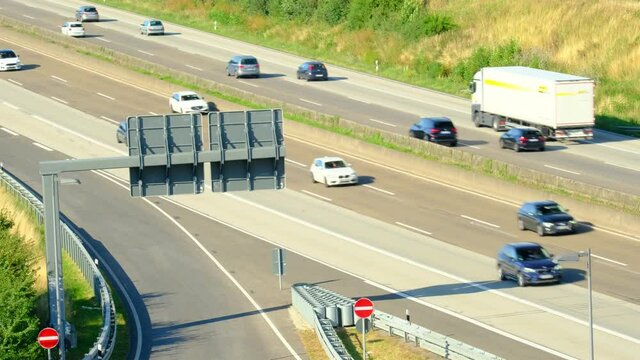 blurred traffic of cars that travel fast on A5 expressway in Germany, daytime traffic in suburbs of Frankfurt am Main, trucking concept, pendlers returning from work, top view