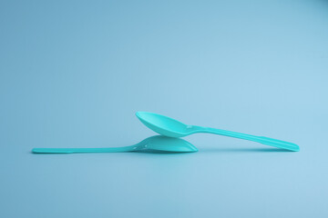 Blue plastic spoon on blue background