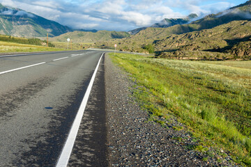 asphalt road in the mountains leading to the mountain peaks