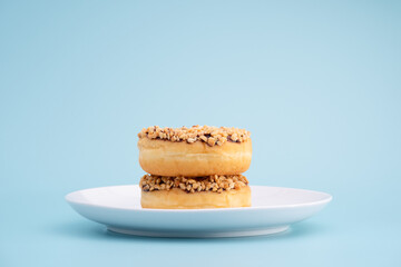 Chocolate donuts, white sugar
and a sprinkling of nuts, on a blue background. 