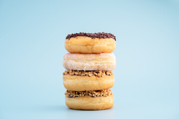 Chocolate donuts, white sugar
and a sprinkling of nuts, on a blue background. 