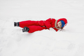 Boy in the red on snow in winter.