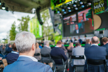 Participants of open air conference listening to speaker