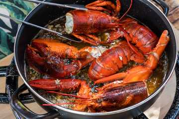 Cooking lobster in a pot with a wooden spoon to make a Spanish paella