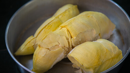 Durian fruit put in aluminium tray on black background.