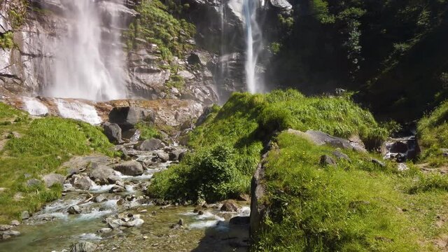 Water stream running from the beautiful Acquafraggia waterfall in Piuro, in the Bregaglia valley in Italy, before the ascent to the Maloja pass. It is a beautiful sunny summer day.