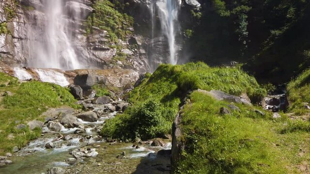 Water stream running from the beautiful Acquafraggia waterfall in Piuro, in the Bregaglia valley in Italy, before the ascent to the Maloja pass. It is a beautiful sunny summer day.