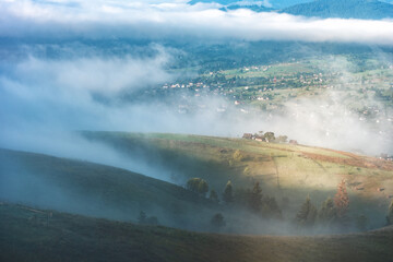 Majestic view of mountain village covered with blue fog