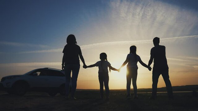 people in the park. happy family a silhouette walk at sunset. car travel kid dream concept. happy family parents and fun children walk silhouette next to car. family sunset walk next to car