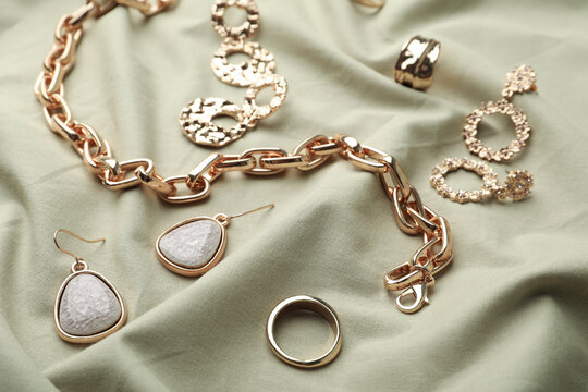 Stylish golden bijouterie on light olive fabric