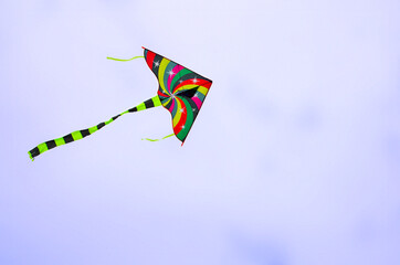 kite in hand on blue sky in sunny weather and wind. Kite fly in summer Freedom. Summer games and fun