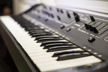Electronic synthesizer (piano keyboard) close-up in the recording studio. Professional audio equipment for a music producer. Create music tracks and hits using a synthesizer.