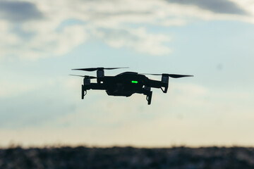 Drone silhouette on sky background with sunset