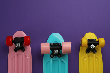 Skateboards on purple background, flat lay. Space for text © New Africa