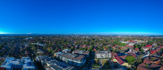 Panoramic Aerial Drone view of Suburban Sydney housing, roof tops, the streets and the parks and CBD Skyline NSW Australia